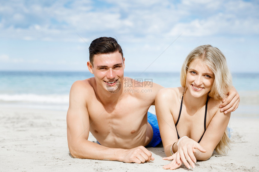 浪漫的轻夫妇海滩上浪漫的轻夫妇海滩上看着相机图片