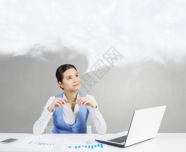 忧郁的女人工作美丽的女人坐桌子上,着笔记本电脑,沉思地看着演讲云图片