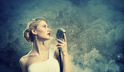 女金发歌手女金发歌手烟雾背景下着麦克风的形象图片