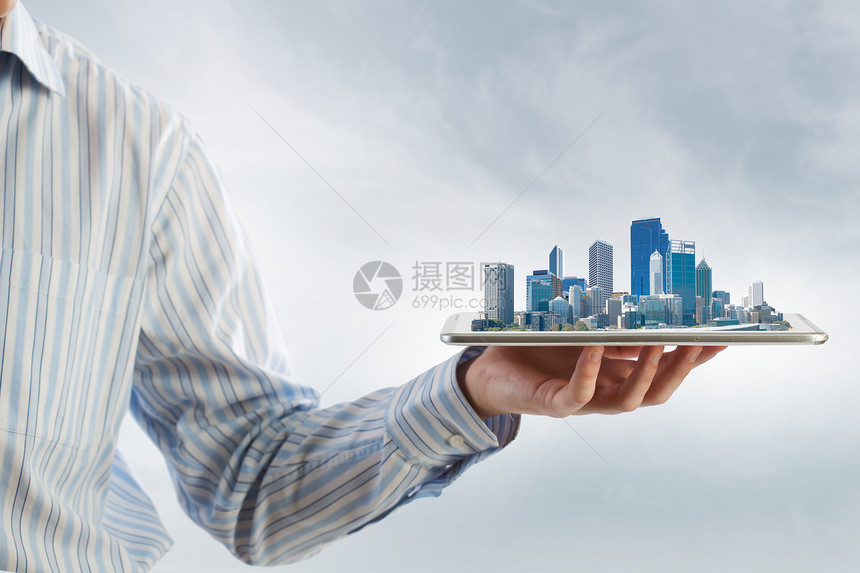 现代城市模式手持平板电脑,屏幕上城市景观图片