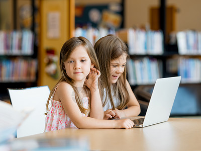 电子书籍图书馆里着笔记本电脑的小女孩图书馆的技术乐趣背景