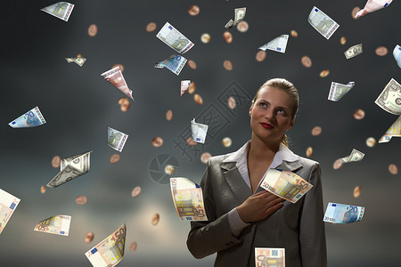 梦想致富轻的女商人站钞票的雨中图片