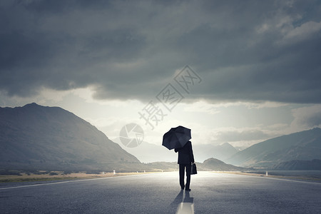 带着黑色雨伞的人带着雨伞手提箱走路上的商人的背景图片