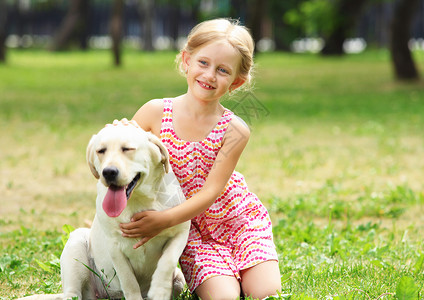 带着她的狗的小女孩个金发的小女孩她的宠物狗公园里超过了他们图片