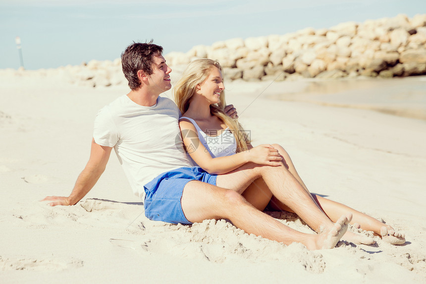 浪漫的轻夫妇坐海滩上浪漫的轻夫妇坐海滩上看着大海图片