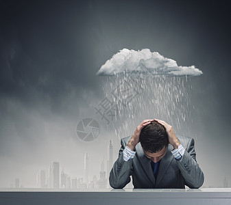 生意上的失败沮丧的轻商人坐雨下湿漉漉的图片