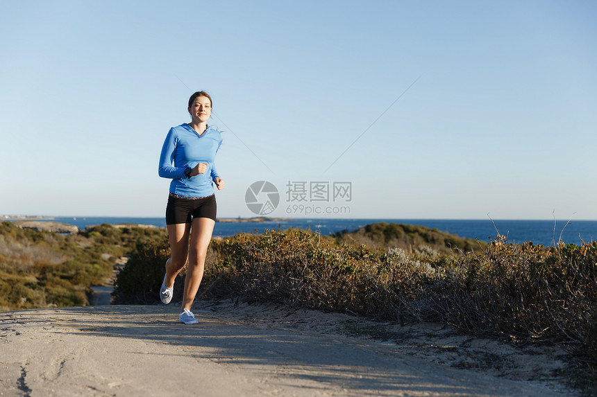 运动跑步者海滩上慢跑锻炼适合女健身模型沿海洋慢跑图片