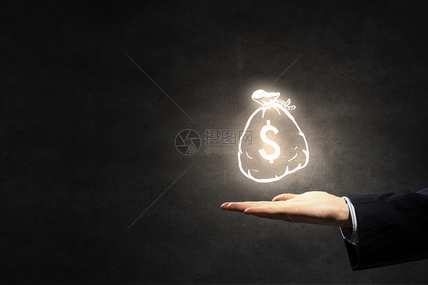 把你的钱投资正确商人黑暗背景上着钱袋符号的手图片