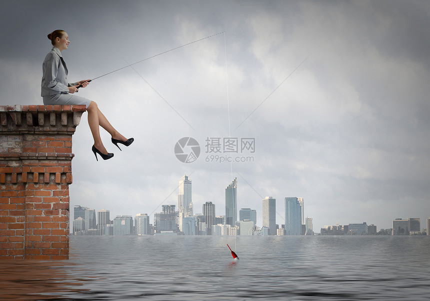 捕鱼的女商人建筑物顶部用棍子钓鱼图片