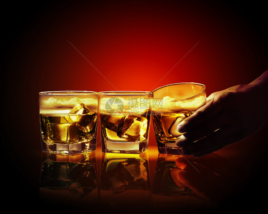 三杯威士忌手着三杯威士忌中的杯,冰天空插图图片