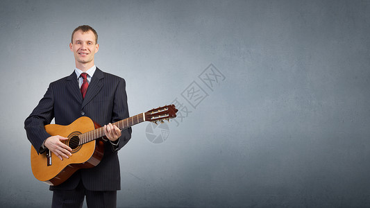 带吉他的男人穿着黑色西装的轻人弹声吉他图片