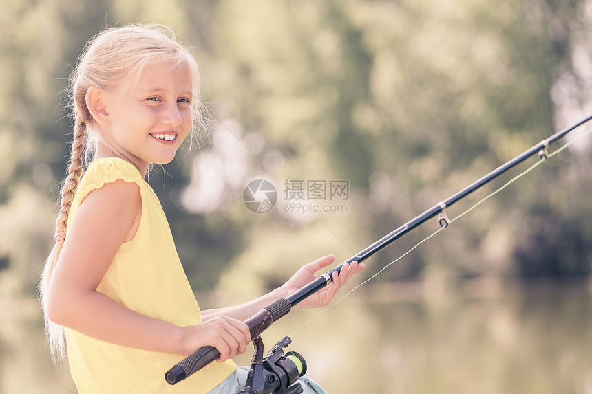 会钓大鱼的坐银行钓鱼的可爱女孩的肖像图片