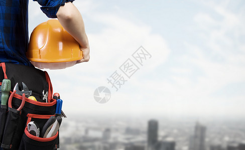 建筑女机械师与黄色头盔手的城市背景背景图片