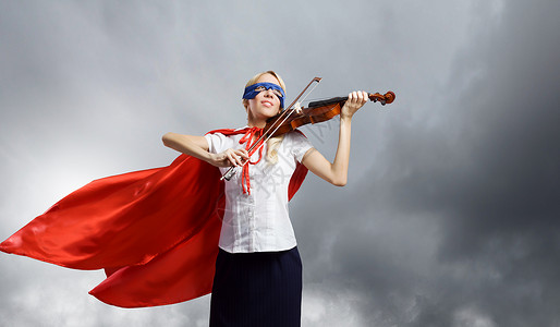 感觉自己个英雄穿着超级英雄服装的轻女人拉小提琴背景图片