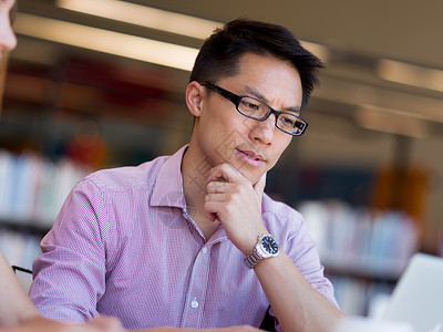 快乐的男学生图书馆工作快乐的亚洲男学生图书馆工作图片