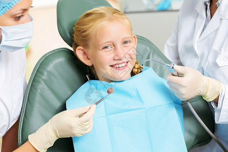 牙齿检查可爱的微笑女孩坐扶手椅上看牙医背景图片