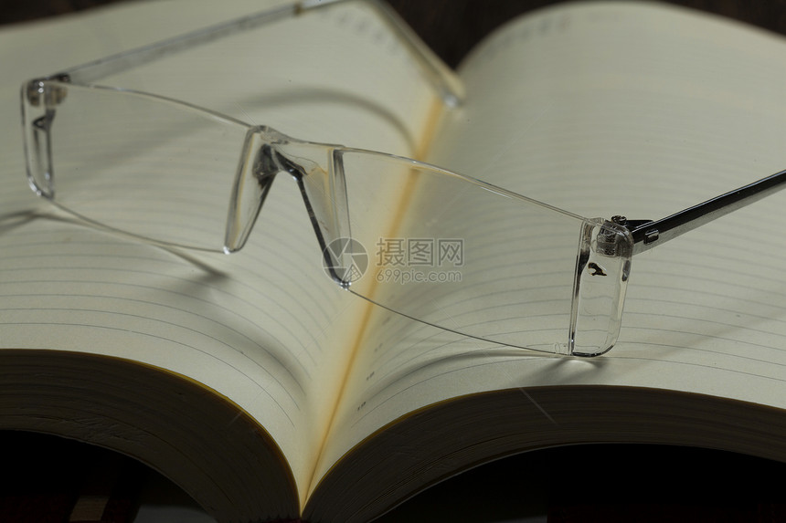 记事本眼镜眼镜躺打开的空白记事本上图片