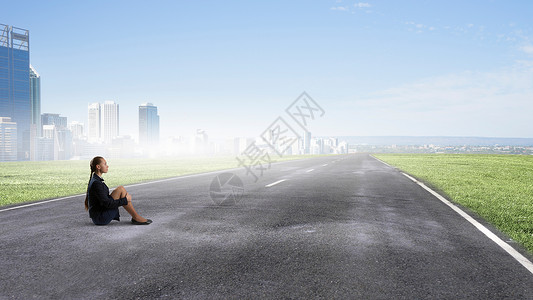 她处于困境孤立之中无聊的轻女商人独自坐沥青路上图片