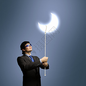 梦想的轻商人戴着护目镜看月亮的形象图片
