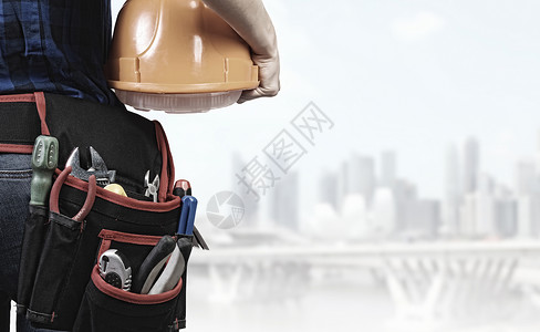 建筑女机械师与黄色头盔手的城市背景图片