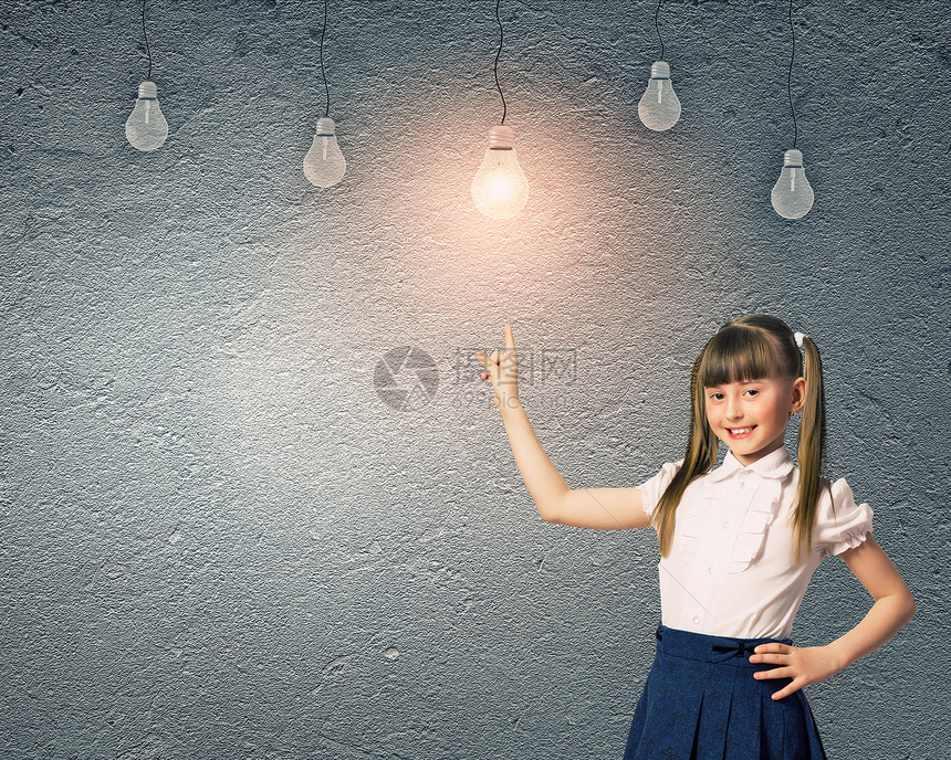 可爱的学校女孩靠灰色的墙上,挂着灯泡神童图片