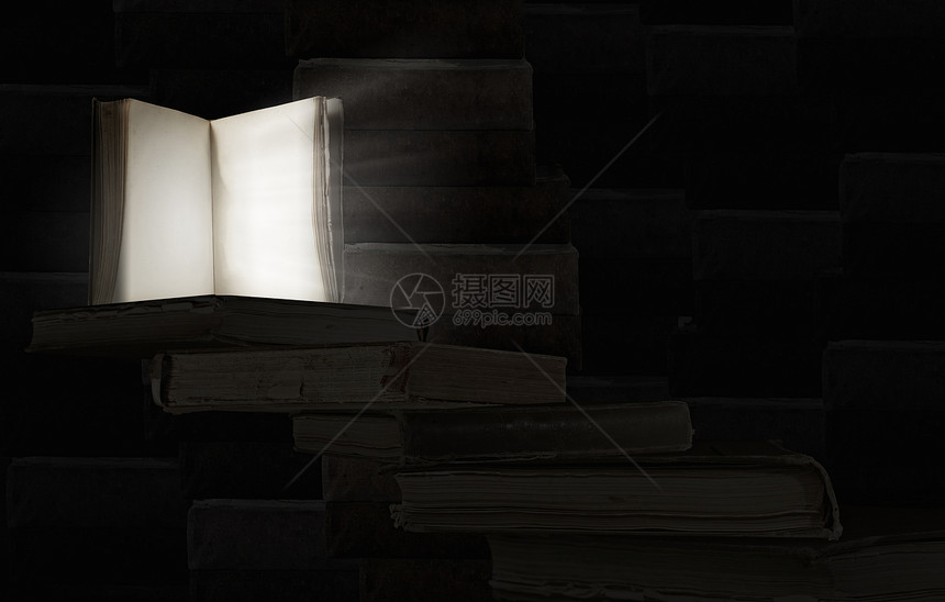 打开了书旧的打开的书,光线来自黑暗背景的页图片