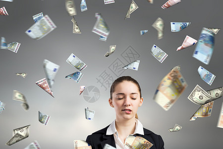 梦想致富轻的女商人站钞票的雨中图片