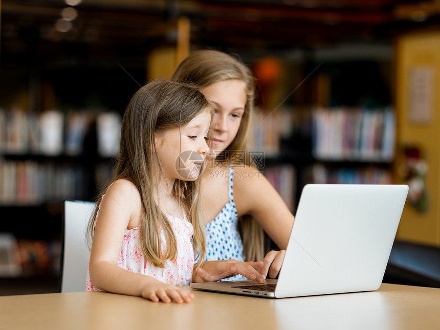 图书馆里着笔记本电脑的小女孩图书馆的技术乐趣图片