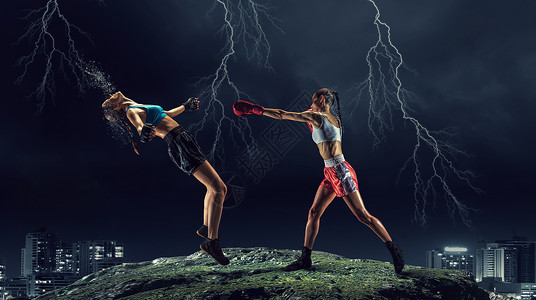 女孩们户外拳击两个轻的漂亮女人夜间城市背景下拳击图片