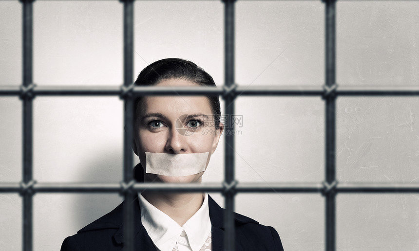 释放无罪的被告轻的女商人,嘴上戴着胶带,双手疲惫图片