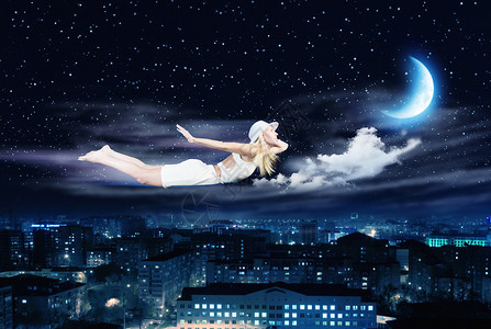 晚上梦轻的金发女孩夜空中飞翔高清图片