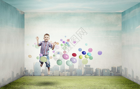 快乐的男孩周围围绕着五颜六色的气球图片