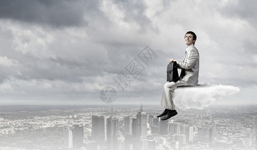 穿西装的商人孤立地坐云端上办公室休息背景