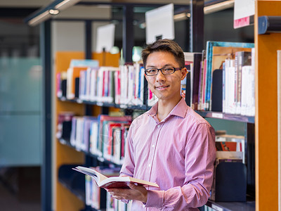 快乐的男学生图书馆书快乐的亚洲男学生图书馆书图片