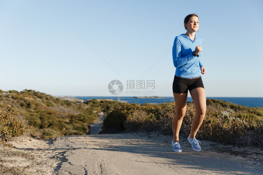 运动跑步者海滩上慢跑锻炼适合女健身模型沿海洋慢跑图片