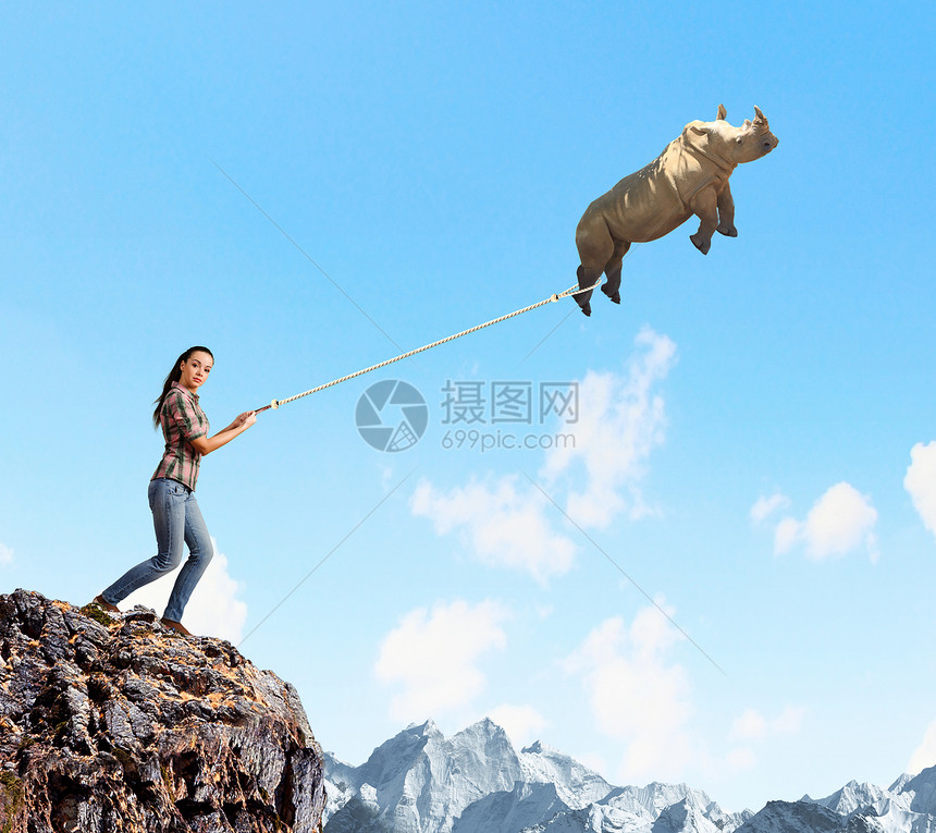 动物园动物轻的女人着飞犀牛绳子上图片