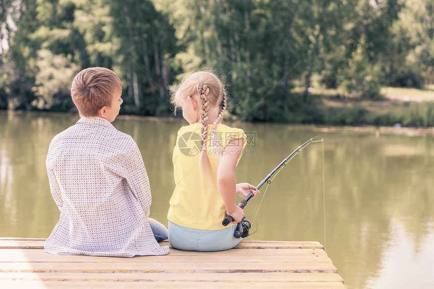 夏季休闲两个孩子坐岸边钓鱼的后视镜图片