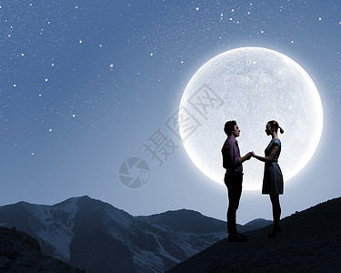 浪漫的约会夫妇大月亮的背景上的剪影图片