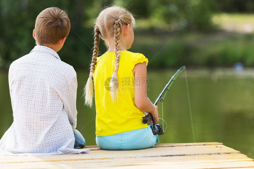 两个孩子坐岸边钓鱼图片