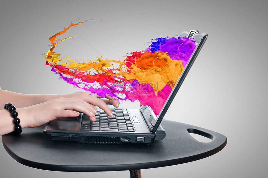 媒体技术女人的手用笔记本电脑彩色飞溅屏幕上图片
