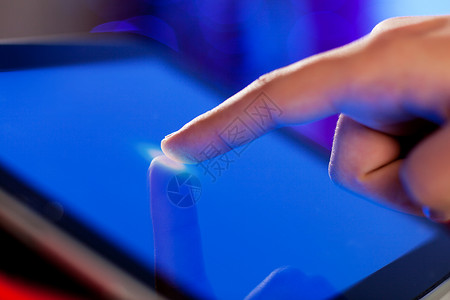 手指触摸屏幕手指触摸蓝色屏幕的特写图像高清图片