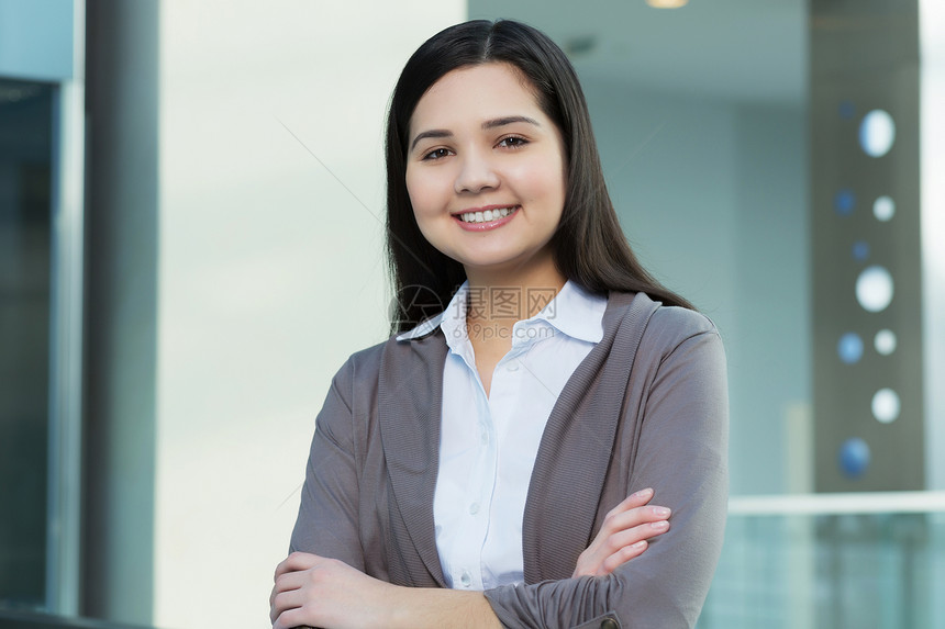 办公楼里魅力的女人轻的黑发女人现代璃内部手臂交叉胸部图片