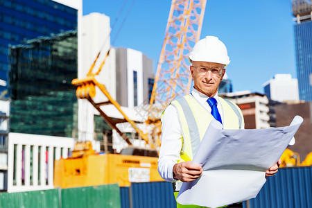 带安全帽素材建筑工地的工程师建设者工程师建筑工人施工场景穿着带蓝图的安全背心背景