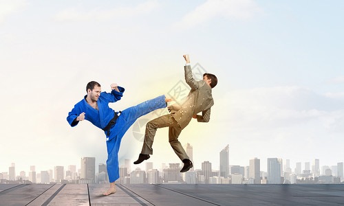 穿着蓝色基米诺的空手道男人轻坚定的空手道男子与西装革履的商人打架背景图片