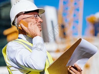 建筑工地的工程师建设者工程师建筑工人施工穿着安全背心记事本背景图片