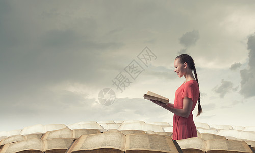 带书的女孩轻的情感女人穿着红色的衣服,手里着书图片