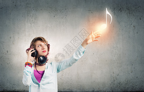 音乐的生活轻的女人戴着耳机,享受着音乐背景图片
