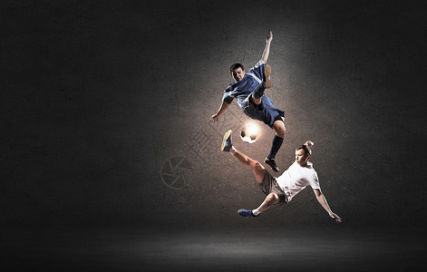 足球运动员两名足球运动员跳跃中争球背景图片