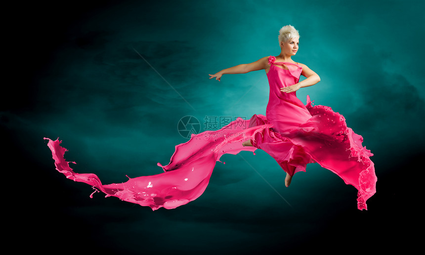 跳跃的女人穿着红色连衣裙的轻迷人的女人跳得很高图片