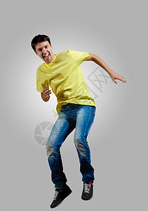 轻人跳舞跳现代苗条嘻哈风格的男人跳灰色背景上跳舞图片